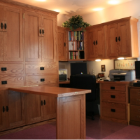 A home office setup featuring a desk, ample shelving, and a Murphy bed integrated into the wall for efficient space usage