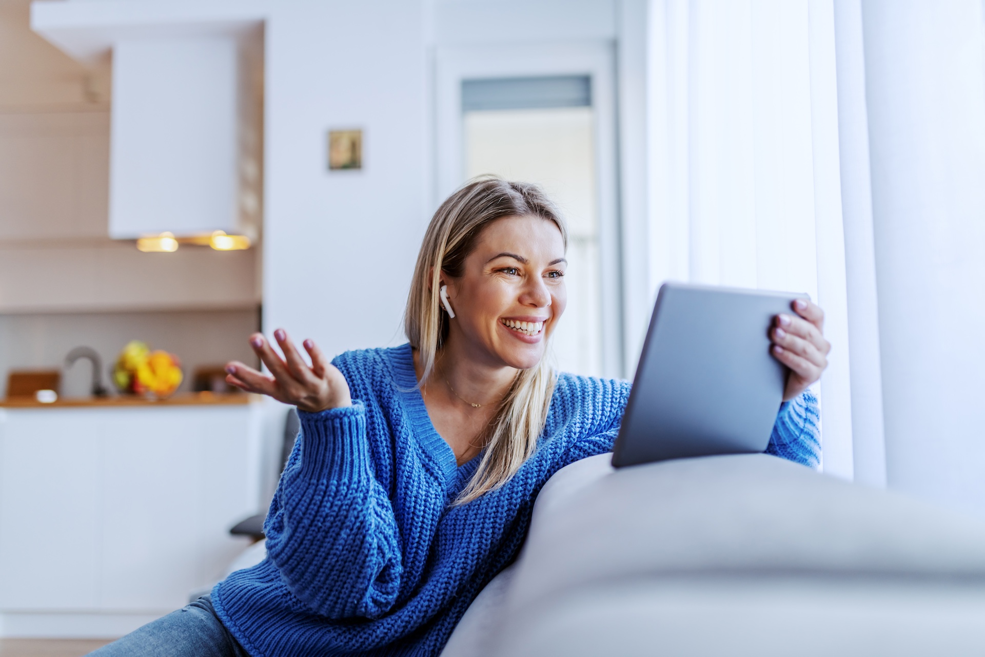 Woman smiling looking at tablet on video call